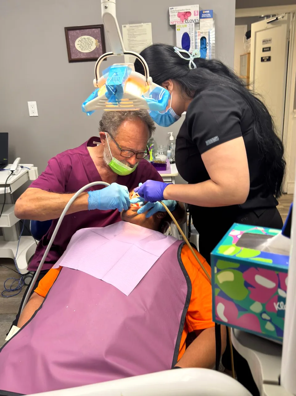 Dentista y asistente de Latino Americano Dental atendiendo a un paciente