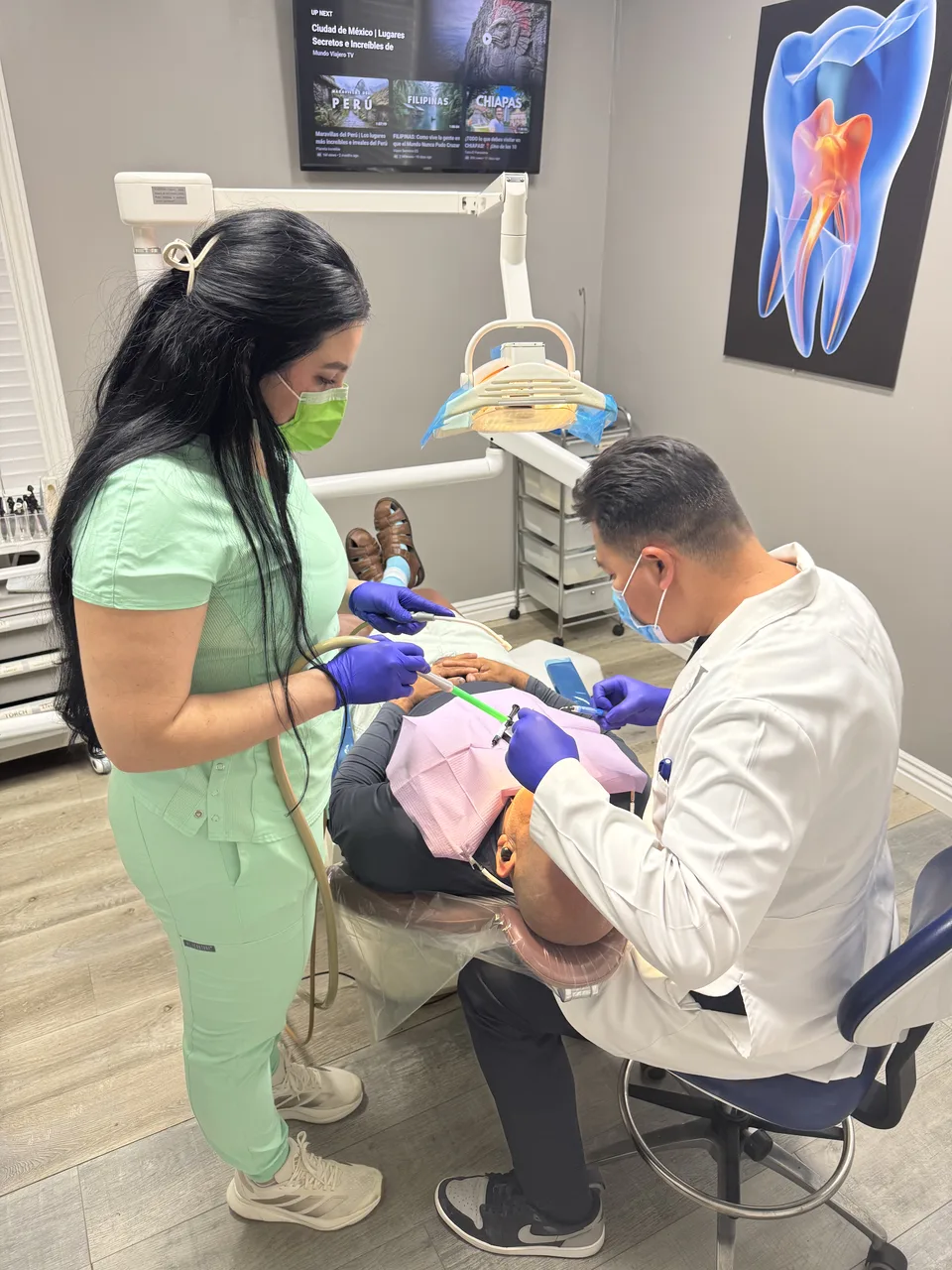 Dentist at Latino Americano Dental checking a patient's bite during a consultation