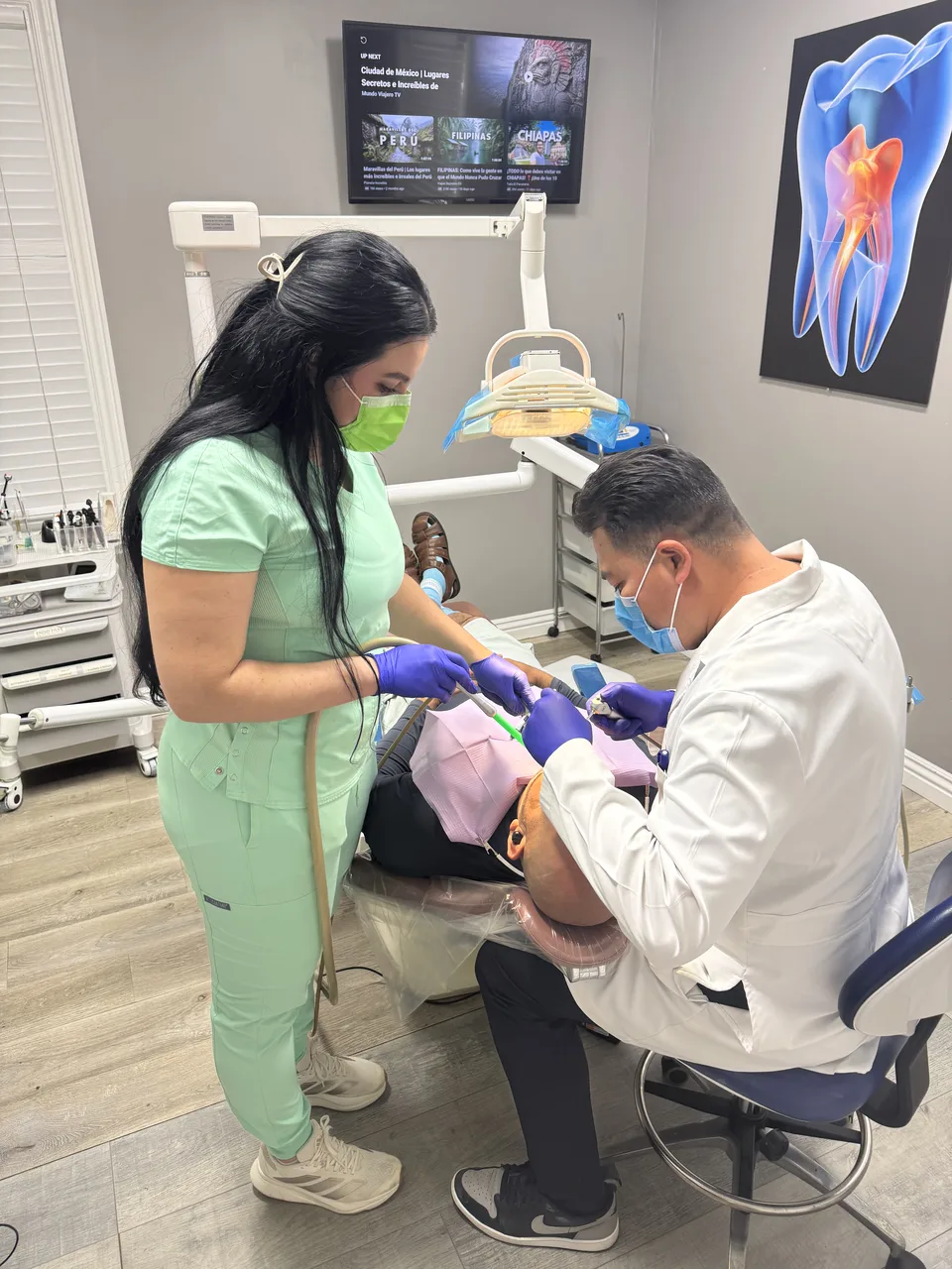 Dentist at Latino Americano Dental checking a patient’s smile at the office