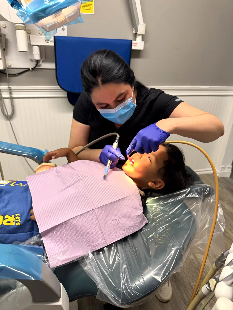 Higienista de Latino Americano Dental atendiendo a una niña en el consultorio de San José